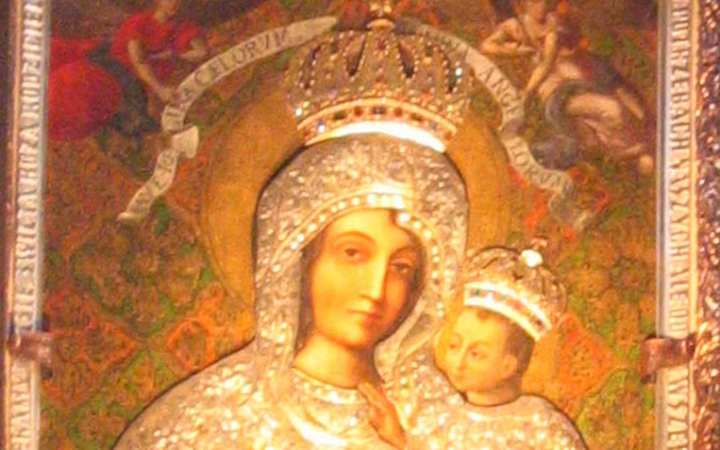 Our Lady of Gietrzwałd — Gietrzwałd. A Baroque painting of the Madonna and Child, both wearing golden crowns. Mary in a red dress and blue mantle, the Child blessing, filling the frame.