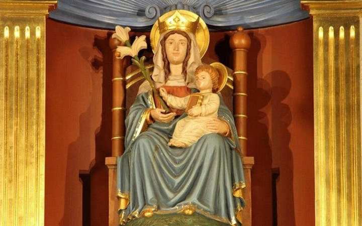 Our Lady of Walsingham — Walsingham, Norfolk. A seated wooden statue: Mary on a throne, the Child on her lap, a lily, both crowned.